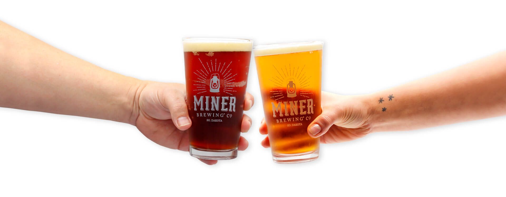 Two pint glasses with Miner Brewing Company craft beer clink together.